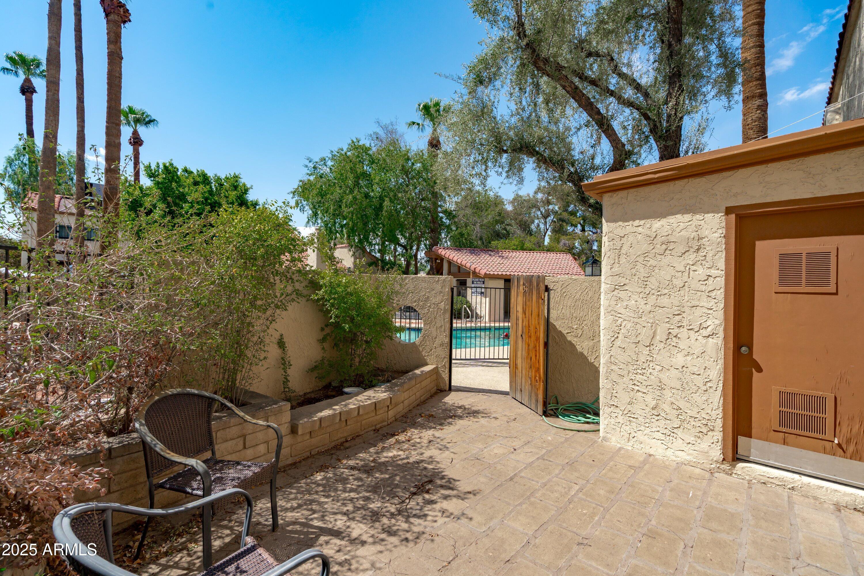 6533 North 7th Avenue, Unit 34 Phoenix, AZ 85013 - Photo 29 of 32 a backyard of a house with wooden fence and a bench