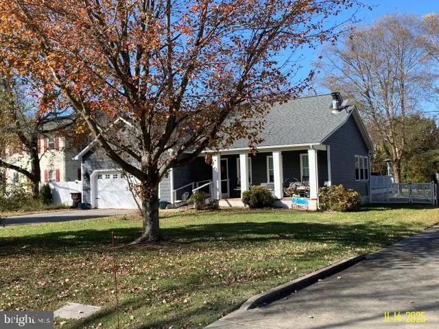 a front view of a house with garden and trees