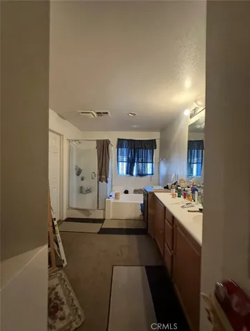 a spacious bathroom with a double vanity sink a large mirror and a bathtub