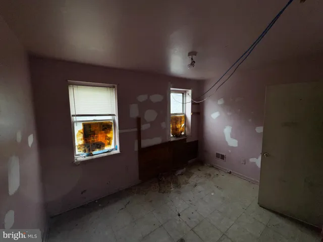 an empty room with windows and fireplace