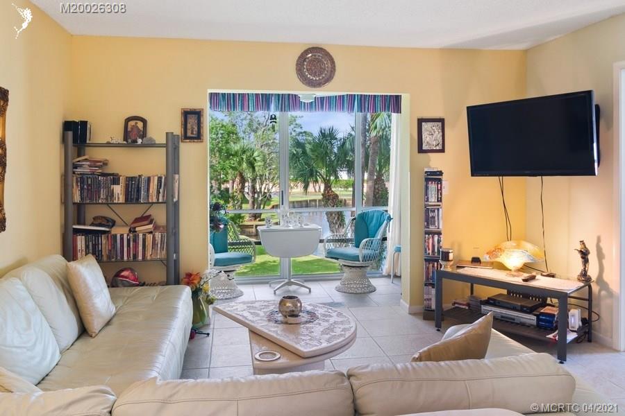 1989 Southwest Palm City Road, Unit J Stuart, FL 34994 - Photo 7 of 16 LIVING ROOOM SPACE WITH VIEWS OF THE POND AND FOUNTAIN