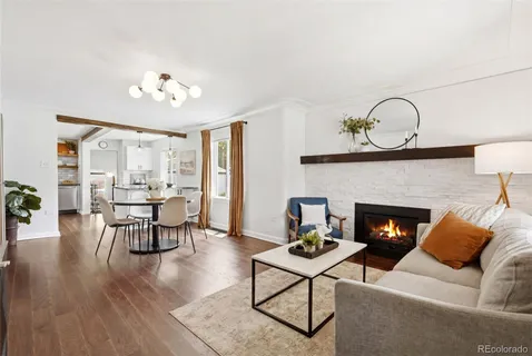 a living room with furniture a fireplace and kitchen view