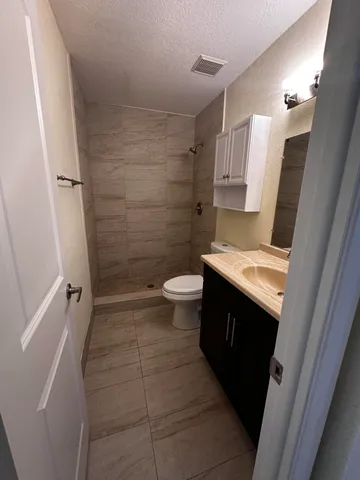 a view of an empty room with wooden floor and closet