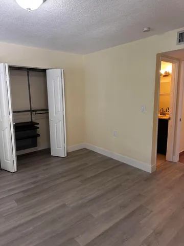 an empty room with wooden floor and window