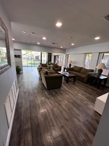 a living room with furniture and a wooden floor