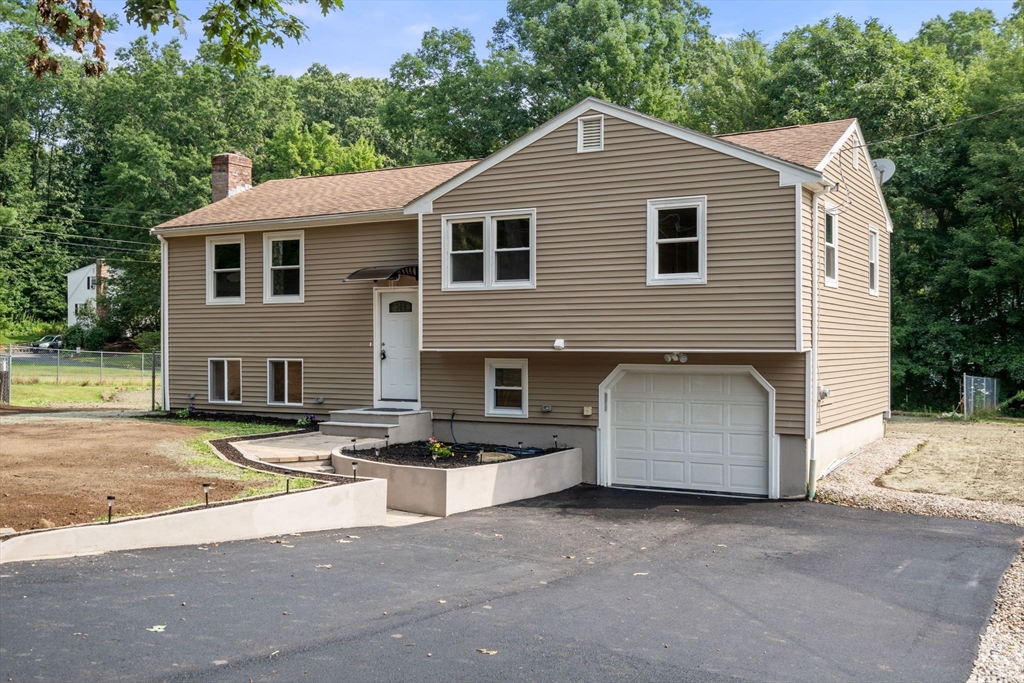 a view of a white house with large windows and palm trees