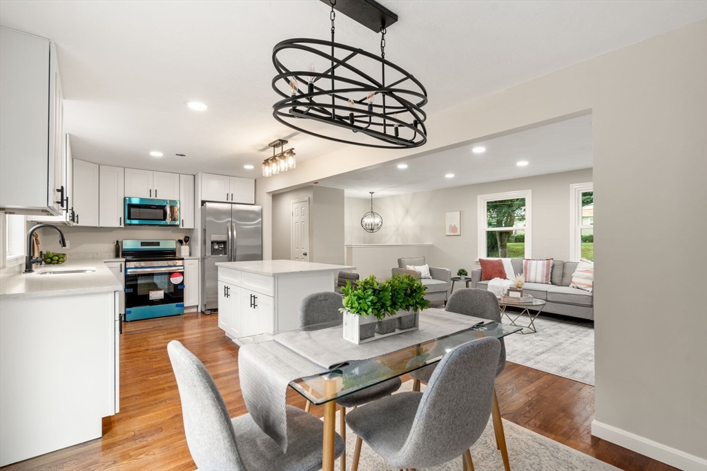 7 Prescott Road Sutton, MA 01588 - Photo 6 of 34 a kitchen with stainless steel appliances kitchen island granite countertop a stove a refrigerator a kitchen island a dining table and chairs with wooden floor