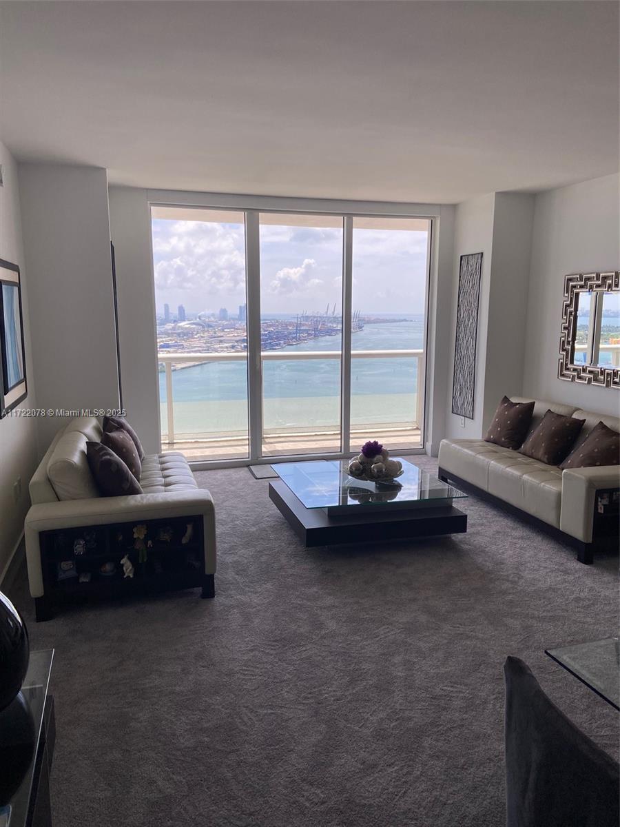 50 Biscayne Boulevard, Unit 2906 Miami, FL 33132 - Photo 2 of 4 a living room with furniture and a floor to ceiling window