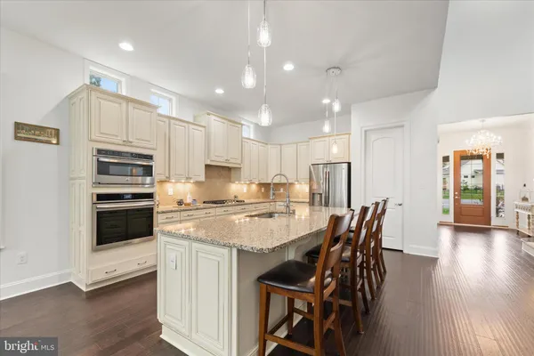 a kitchen with kitchen island a stove a table and chairs in it