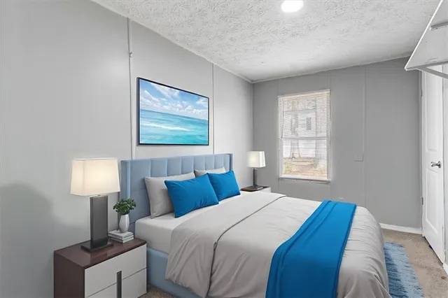 a bedroom with a bed and a lamp on dresser