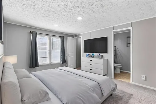 a bedroom with a flat screen tv a bed and a flat screen tv