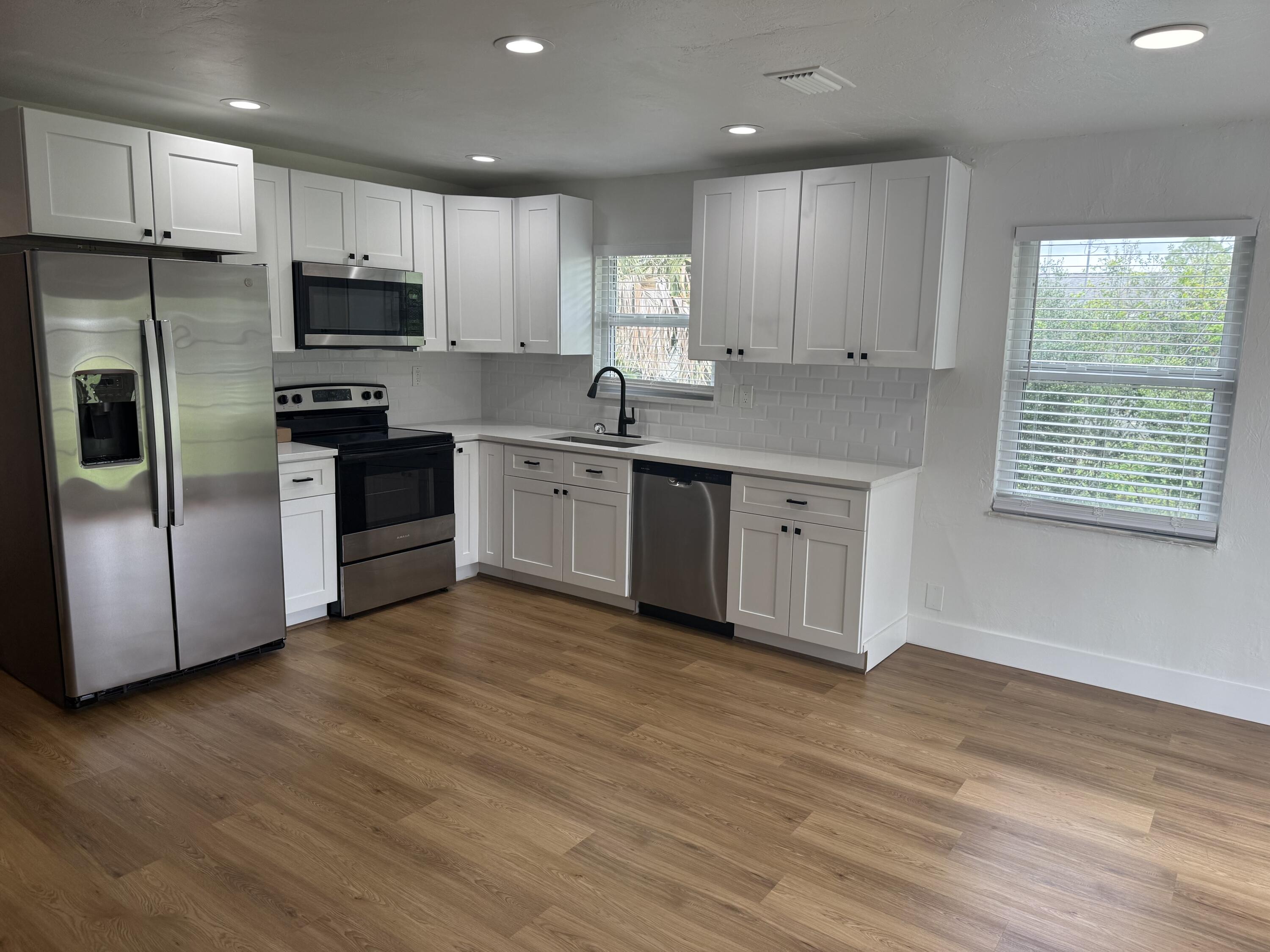 6257 Kendrick Street, Unit 2 Jupiter, FL 33458 - Photo 2 of 11 a kitchen with stainless steel appliances granite countertop a stove a sink and a refrigerator