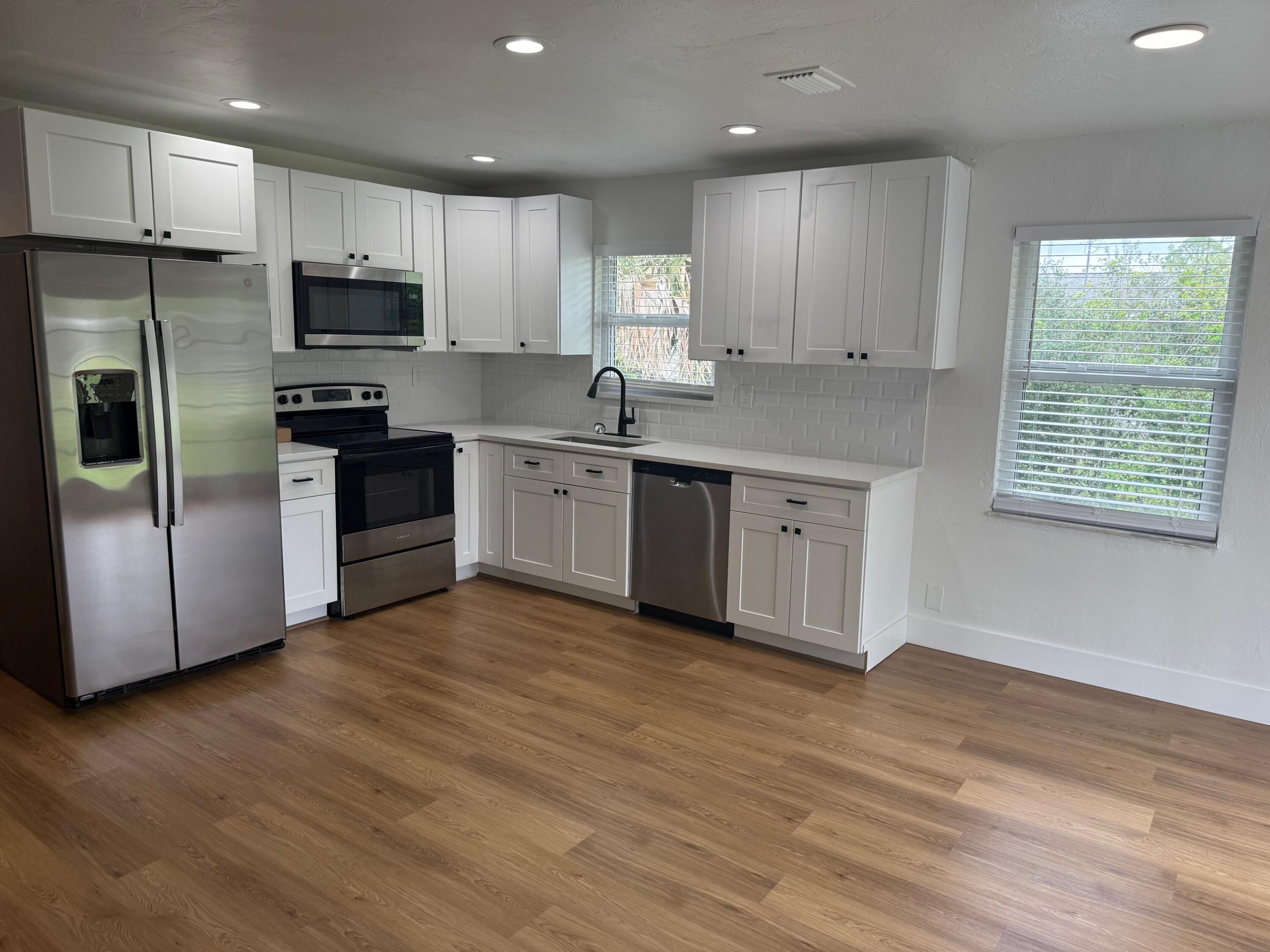 6257 Kendrick Street, Unit 2 Jupiter, FL 33458 - Photo 5 of 11 a kitchen with stainless steel appliances granite countertop a stove a sink and a refrigerator