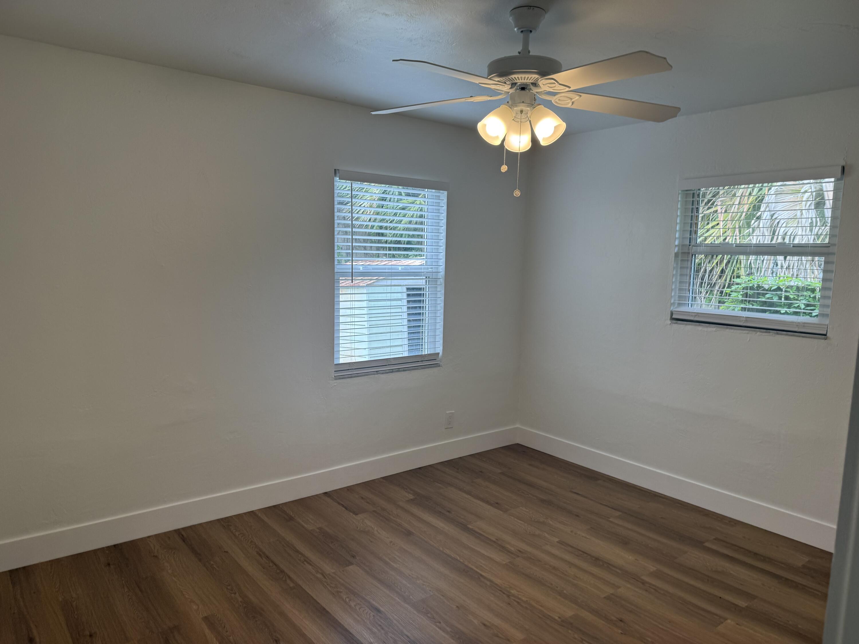 6257 Kendrick Street, Unit 2 Jupiter, FL 33458 - Photo 6 of 11 an empty room with wooden floor and windows
