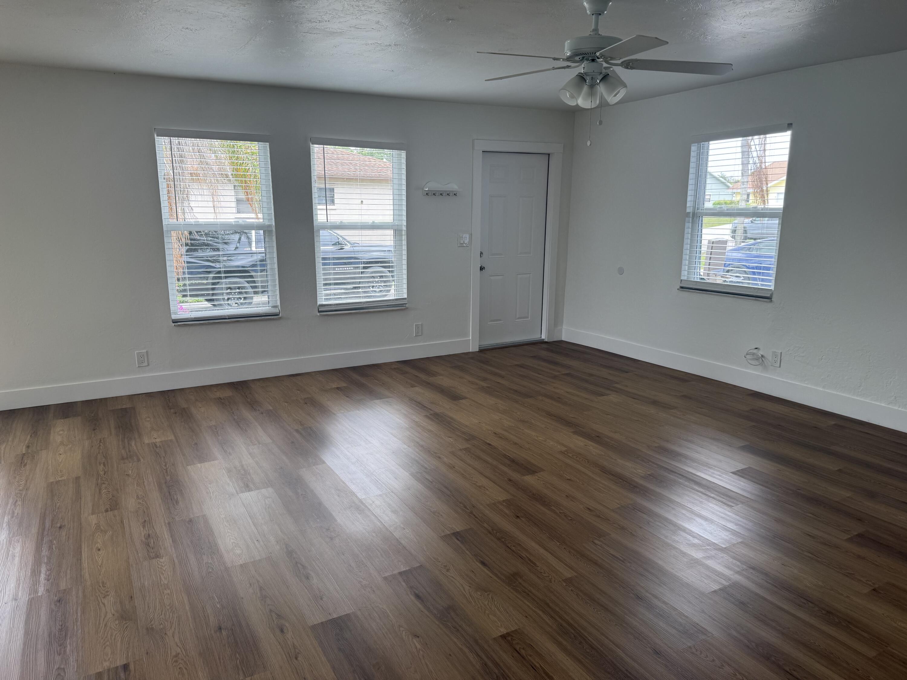 6257 Kendrick Street, Unit 2 Jupiter, FL 33458 - Photo 7 of 11 a view of an empty room with wooden floor and a window