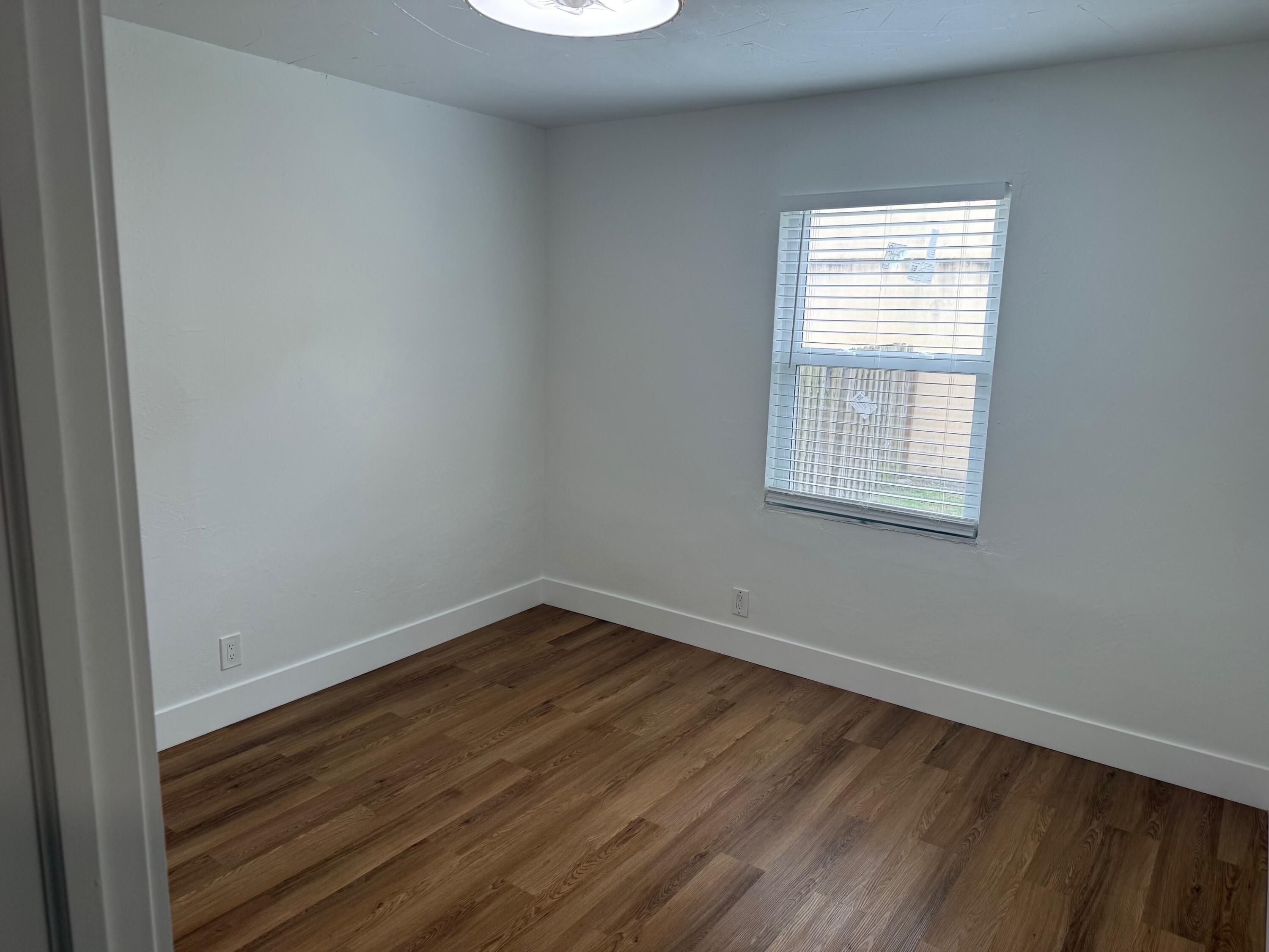 6257 Kendrick Street, Unit 2 Jupiter, FL 33458 - Photo 8 of 11 wooden floor in an empty room with a window