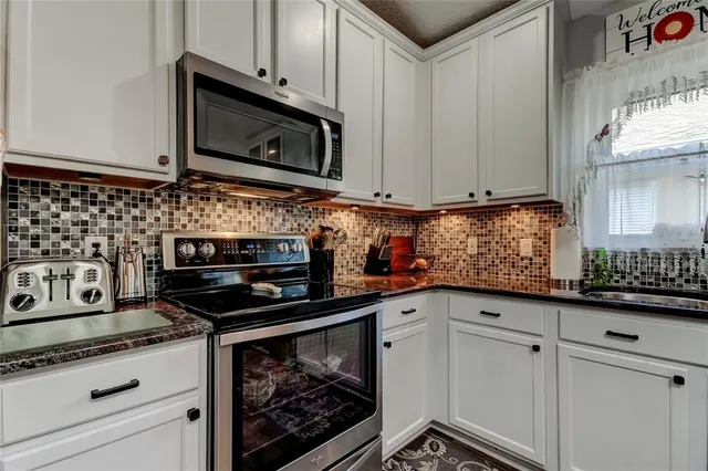 a kitchen with stainless steel appliances granite countertop a refrigerator stove and microwave