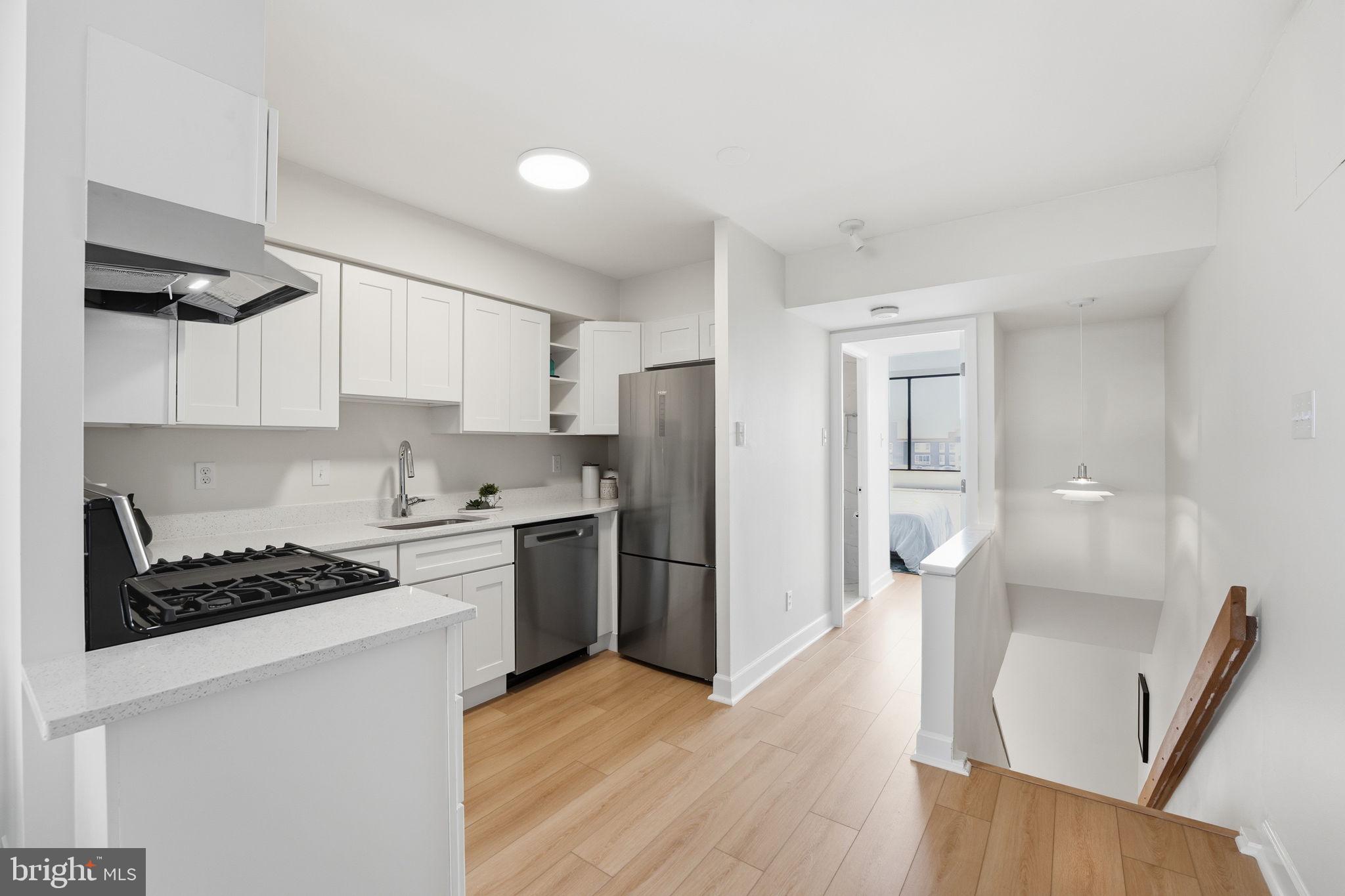 1245 13th Street Northwest, Unit 901 Washington, DC 20005 - Photo 12 of 38 a kitchen with stainless steel appliances a refrigerator stove and wooden floor