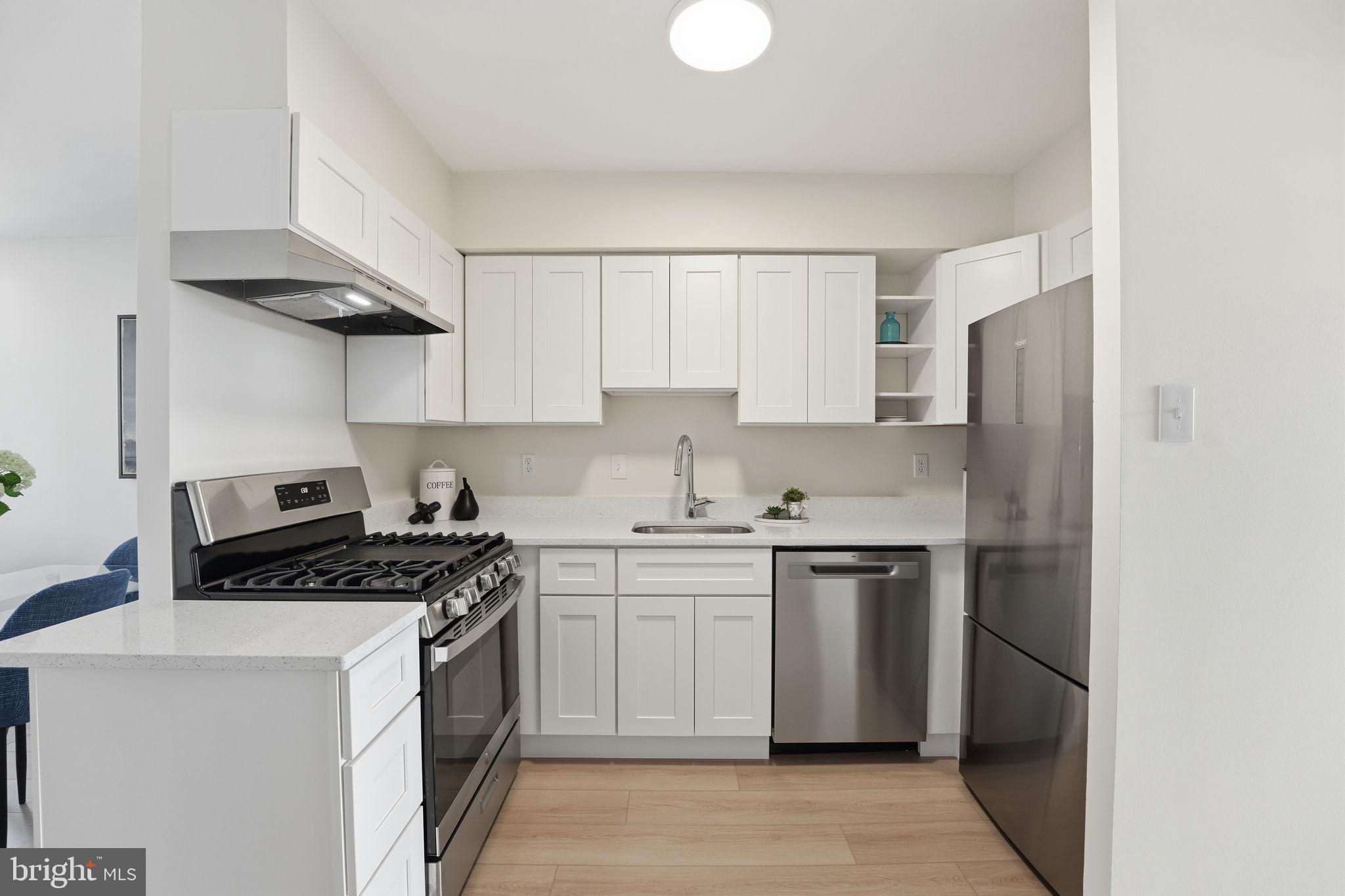 1245 13th Street Northwest, Unit 901 Washington, DC 20005 - Photo 13 of 38 a kitchen with stainless steel appliances granite countertop white cabinets a stove a sink and a refrigerator