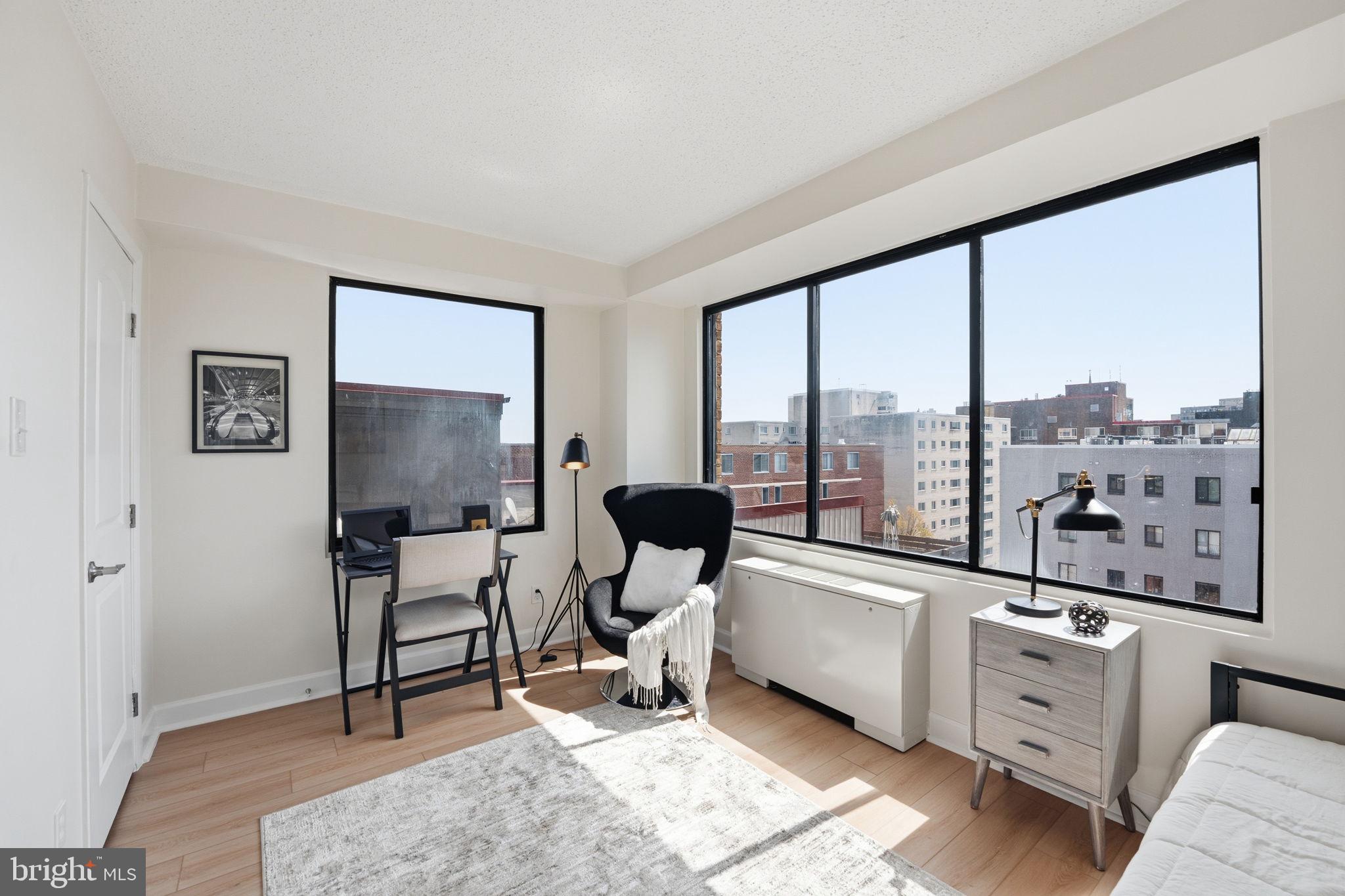 1245 13th Street Northwest, Unit 901 Washington, DC 20005 - Photo 6 of 38 a living room with furniture a flat screen tv and a floor to ceiling window