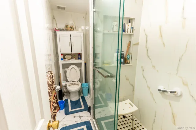 a bathroom with a granite countertop shower and a mirror