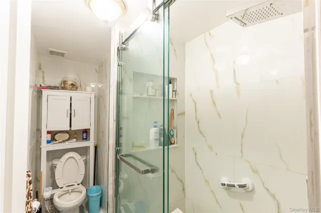 a bathroom with a granite countertop shower and a mirror