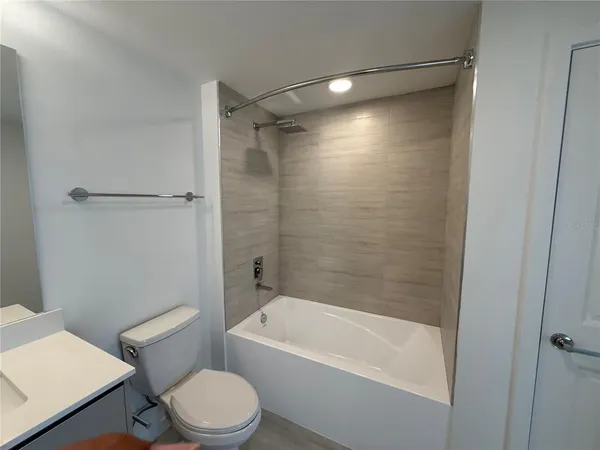 a white toilet sitting next to a bath tub