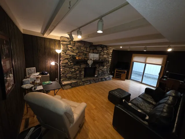 a kitchen with stainless steel appliances a dining table chairs refrigerator and sink