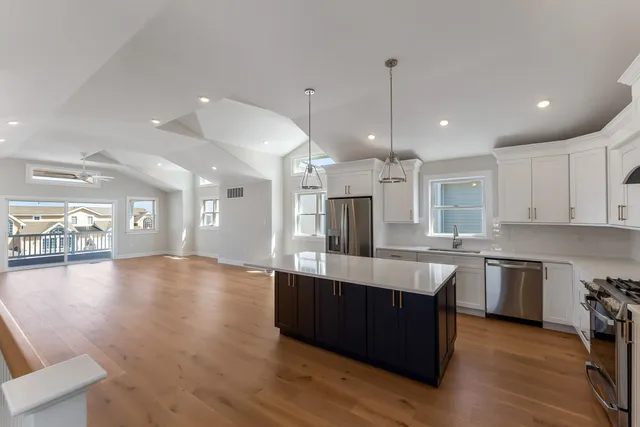 a large kitchen with stainless steel appliances lots of counter space sink refrigerator and cabinets