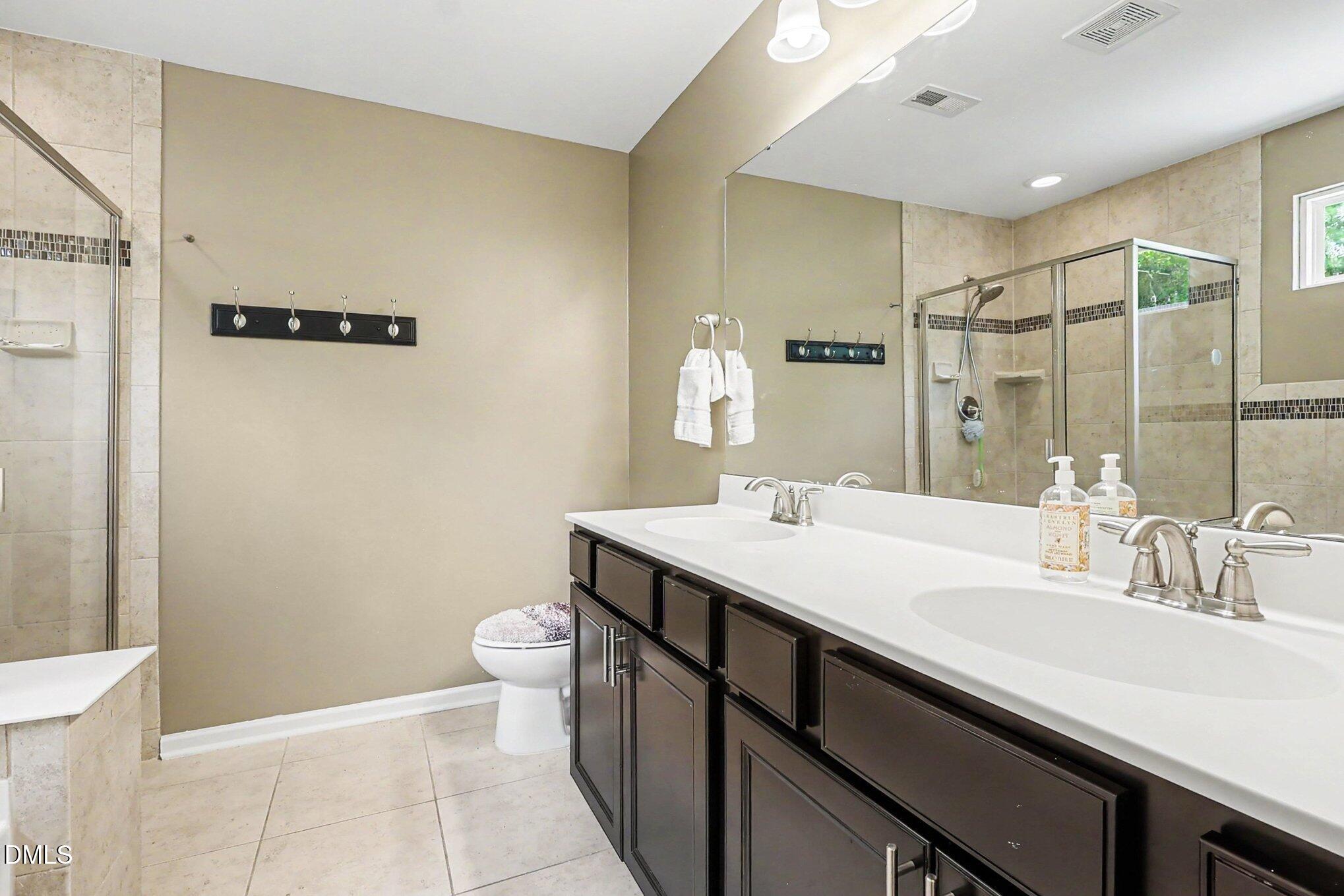 4366 Auburn Hills Drive Raleigh, NC 27616 - Photo 26 of 40 a bathroom with a sink a toilet a shower and a mirror