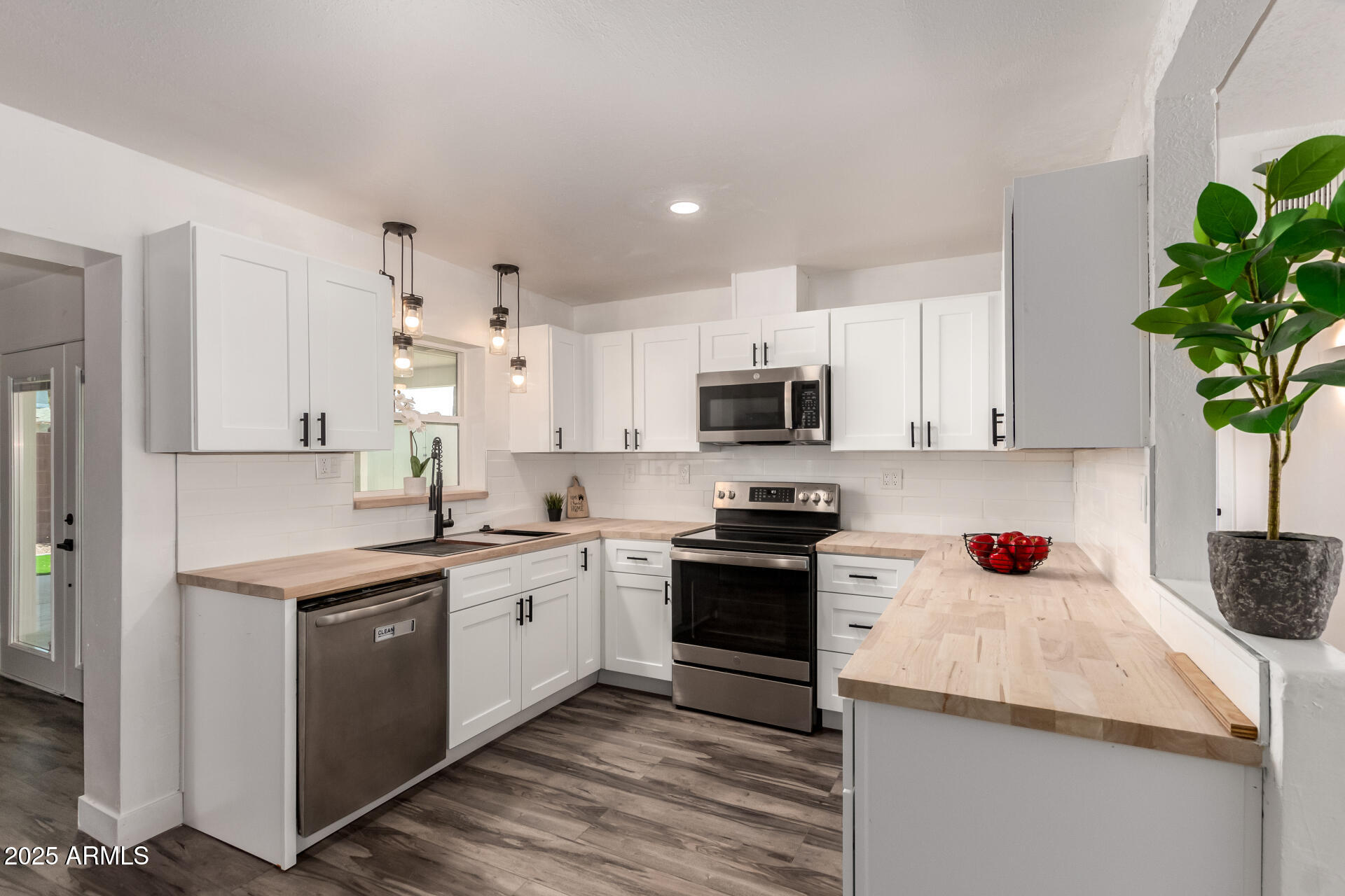 a kitchen with stainless steel appliances kitchen island granite countertop a sink a stove and cabinets