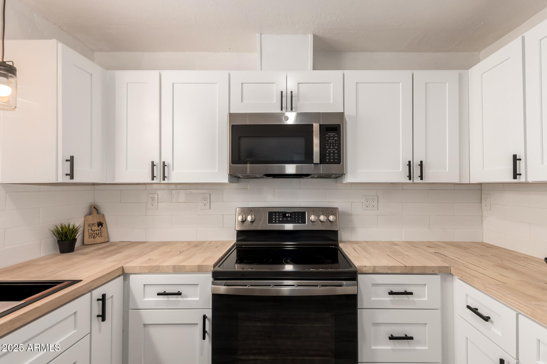 39 North Maple Mesa, AZ 85205 - Photo 11 of 29 a kitchen with white cabinets and black appliances