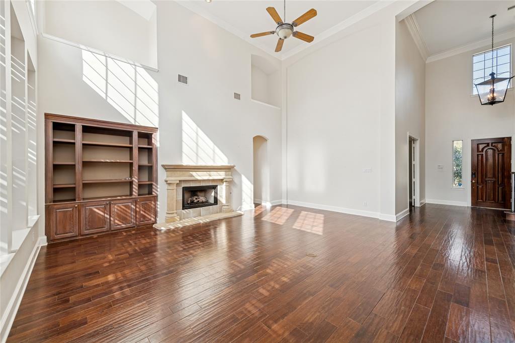 2107 Spindletop Trail Frisco, TX 75033 - Photo 13 of 39 a view of a livingroom with a fireplace a ceiling fan and wooden floor