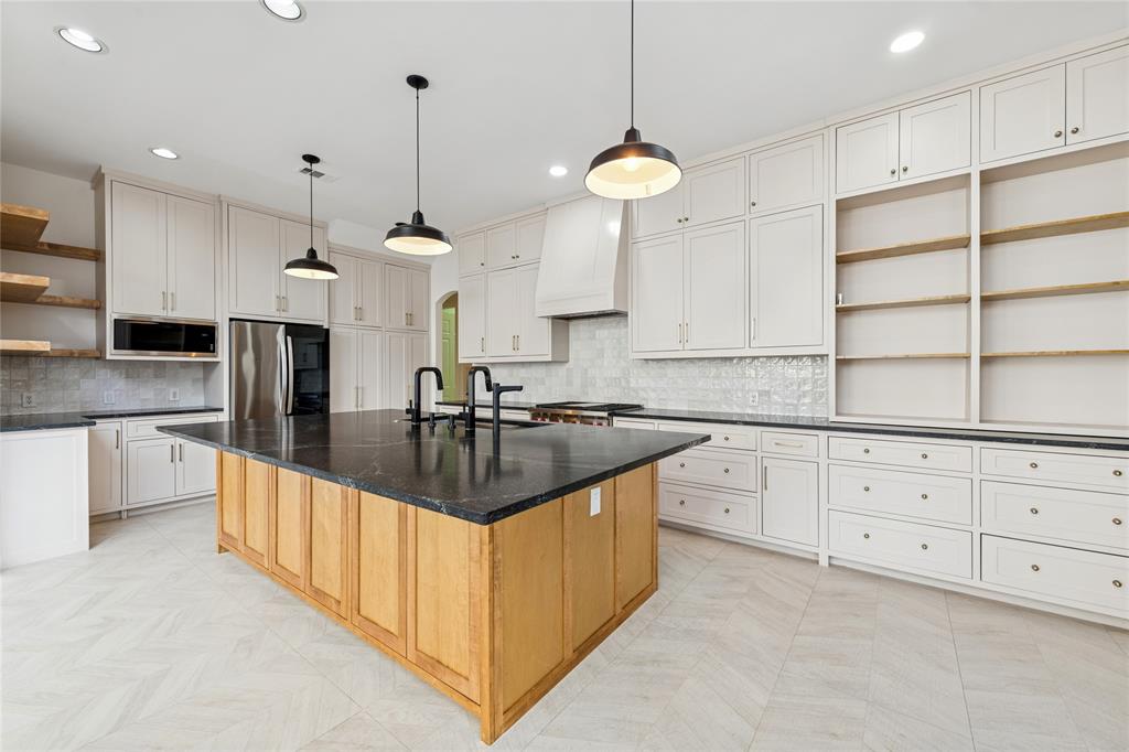 2107 Spindletop Trail Frisco, TX 75033 - Photo 15 of 39 a kitchen with kitchen island granite countertop a sink a counter top space stainless steel appliances and cabinets