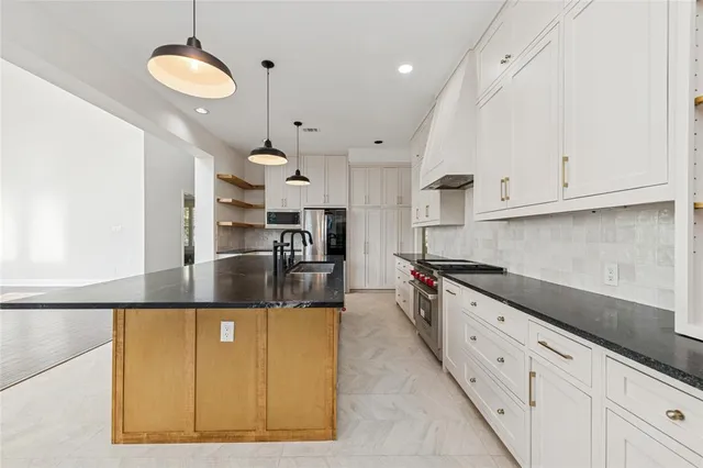 a kitchen with stainless steel appliances granite countertop a sink and cabinets
