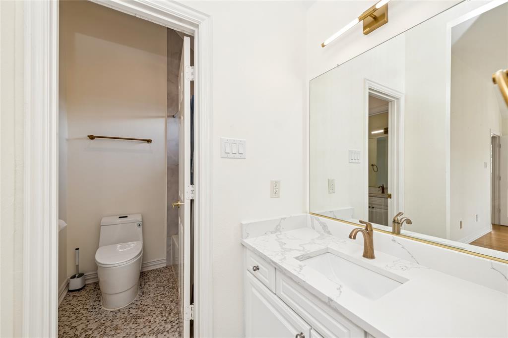 2107 Spindletop Trail Frisco, TX 75033 - Photo 28 of 39 a bathroom with a granite countertop sink a toilet and a large mirror