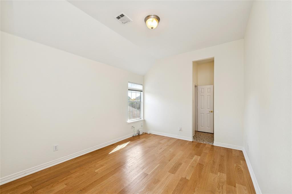 2107 Spindletop Trail Frisco, TX 75033 - Photo 30 of 39 an empty room with wooden floor and windows