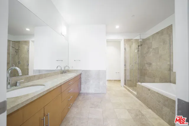 a bathroom with a granite countertop sink a toilet a mirror and bathtub
