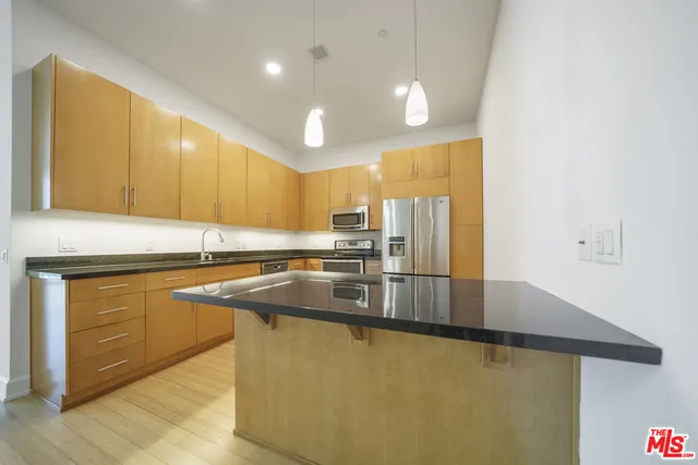 a kitchen with stainless steel appliances granite countertop a sink a stove and a refrigerator