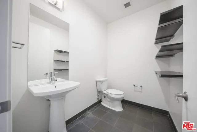 a bathroom with a sink toilet and a mirror