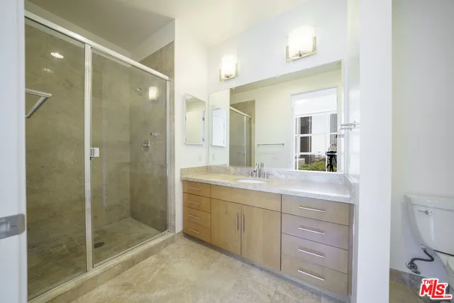 a spacious bathroom with a shower sink mirror and toilet