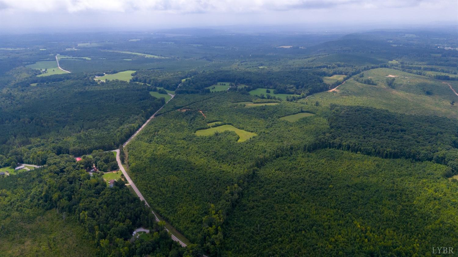 an aerial view of residential houses with outdoor space and trees