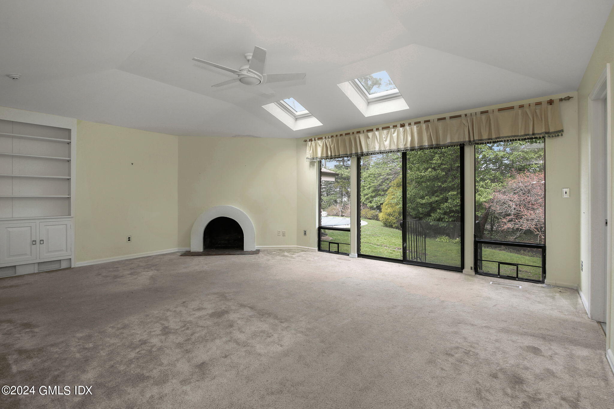 1 Seagate Road Riverside, CT 06878 - Photo 7 of 16 a view of an empty room with a fireplace and a large window