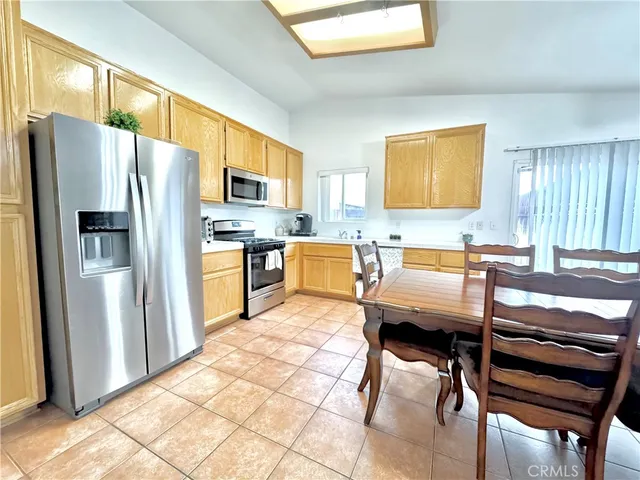 a kitchen with stainless steel appliances kitchen island granite countertop a refrigerator stove top oven and sink