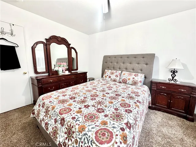 a bedroom with a bed and a dresser with mirror