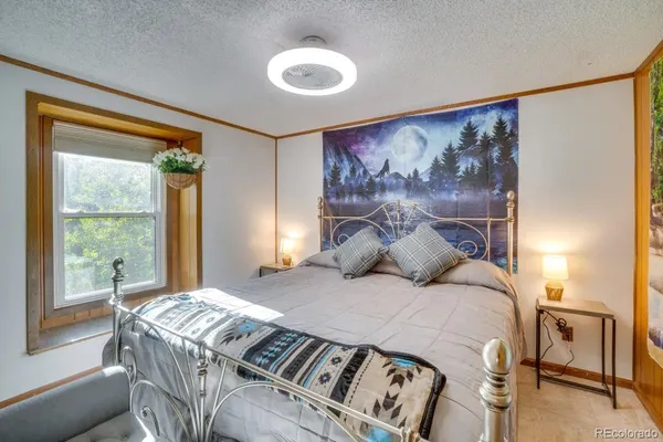 a bedroom with a bed and a painting on the wall