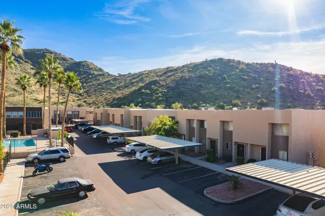 a view of a patio with couches table and chairs with wooden floor and fence