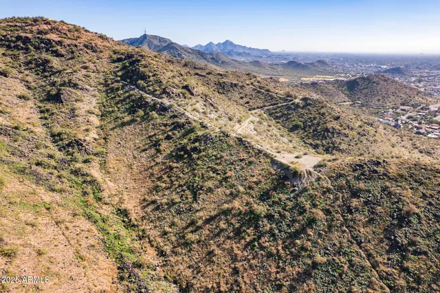a view of a dry yard with mountains in the background