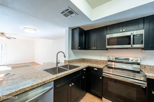 a kitchen with a sink stainless steel appliances and cabinets