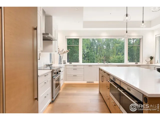 a large white kitchen with a large window